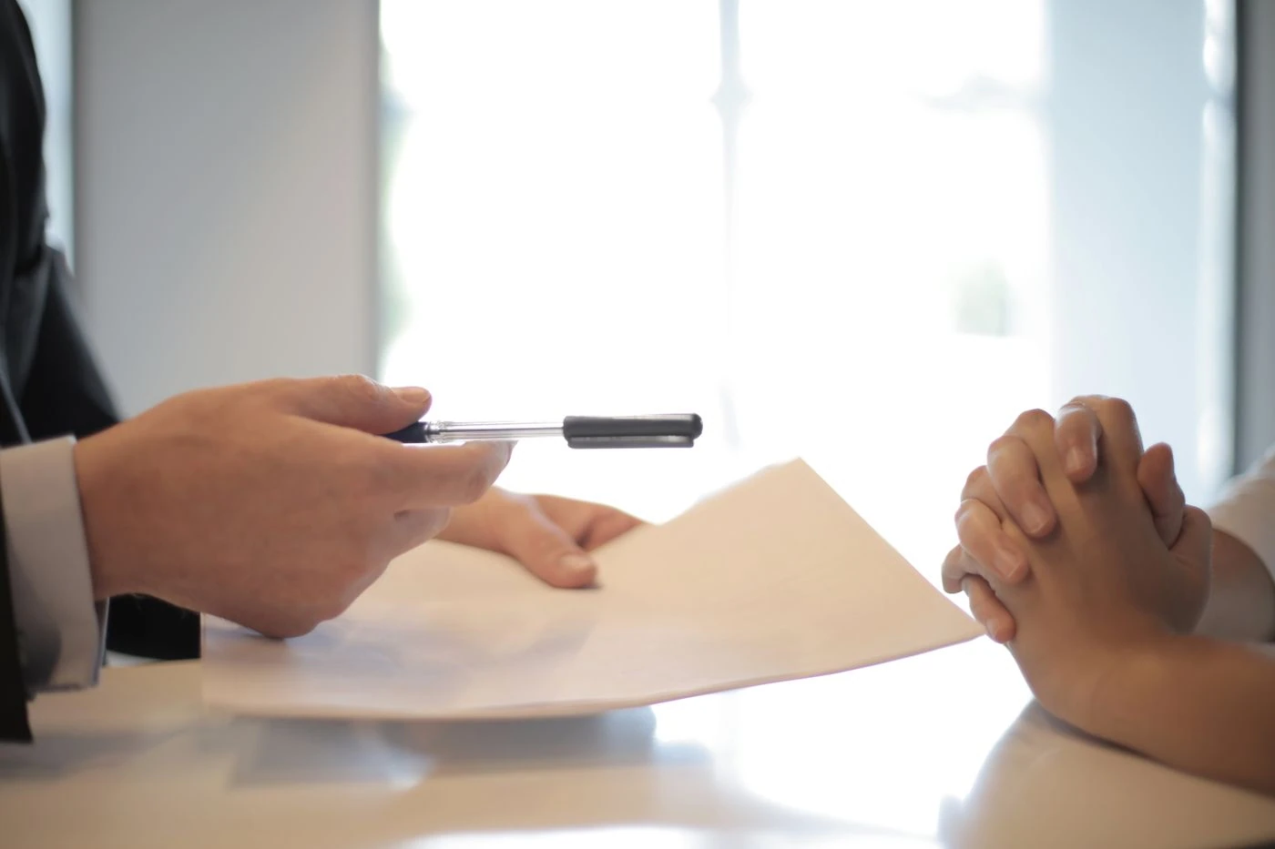 Crop businessman giving contract to woman to sign · Free Stock Photo — illustrative context