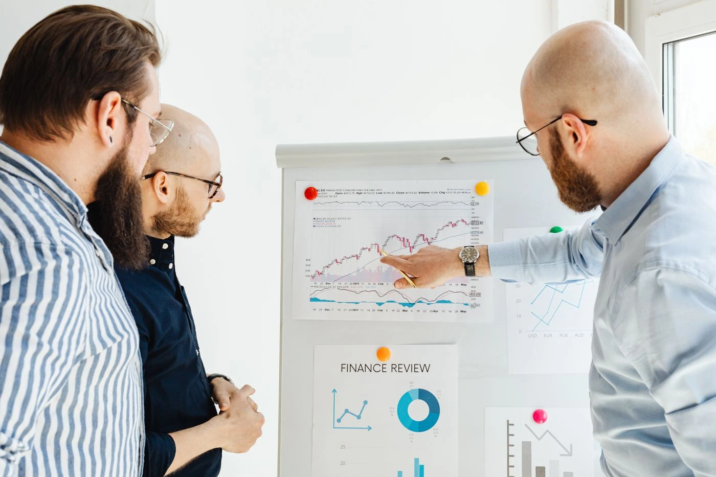 Three Men Discussing a Finance Report · Free Stock Photo — illustrative context