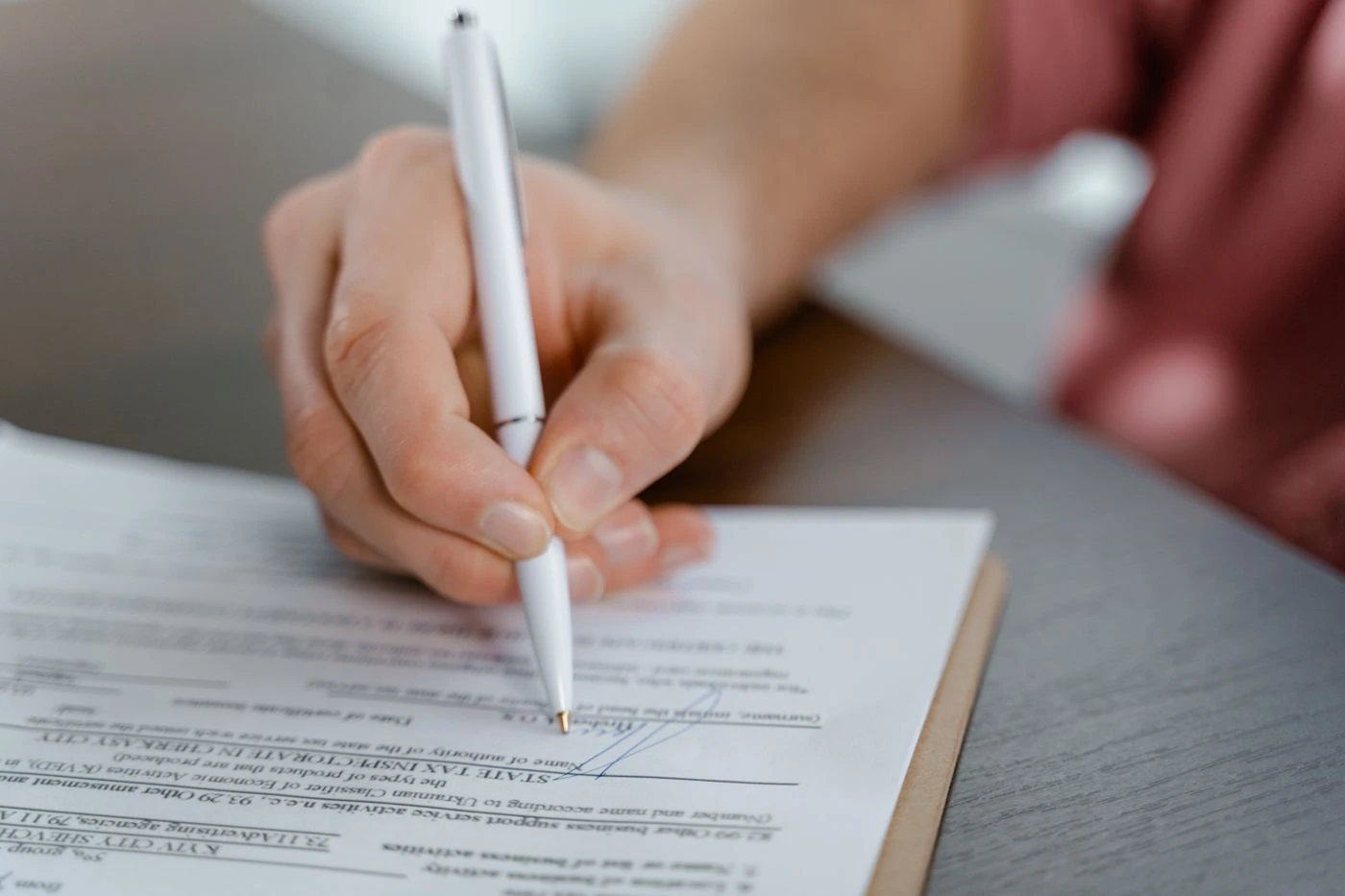 Person Signing on a Paper · Free Stock Photo — illustrative context