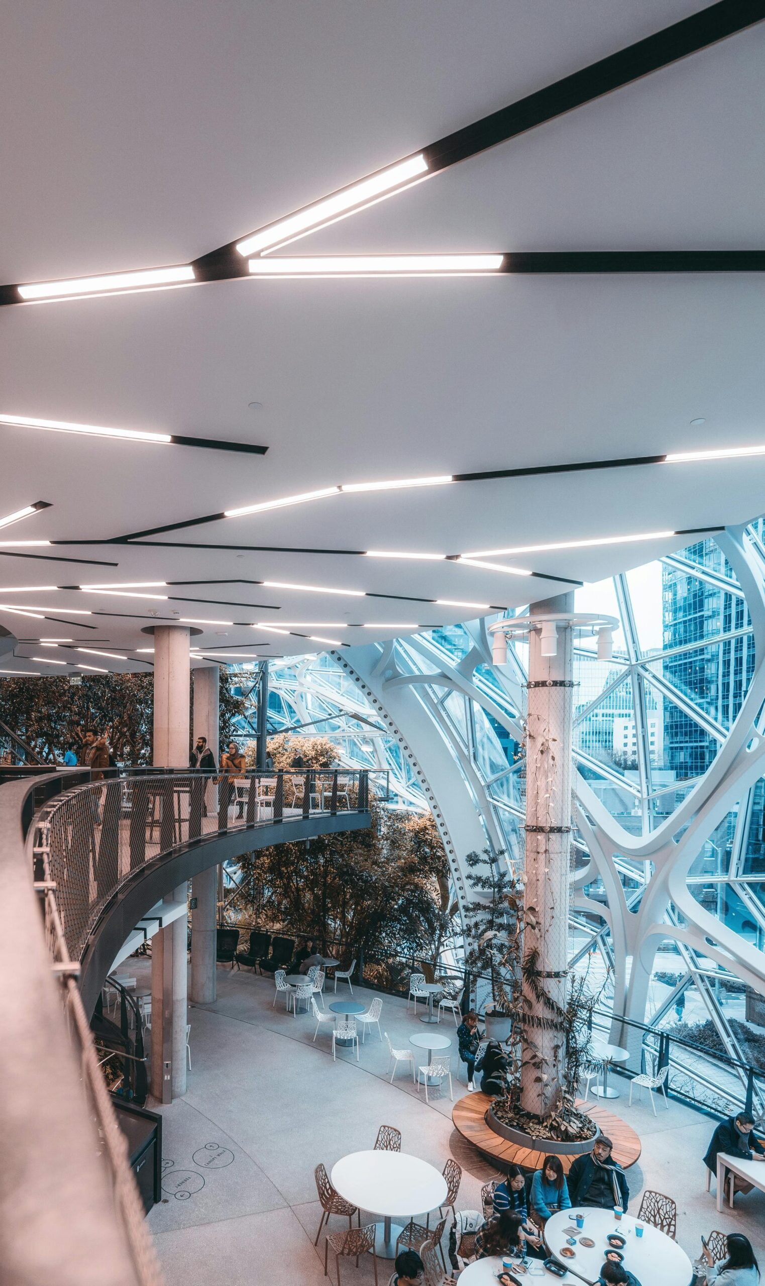 A contemporary indoor space featuring futuristic architecture, glass panels, and lush greenery.